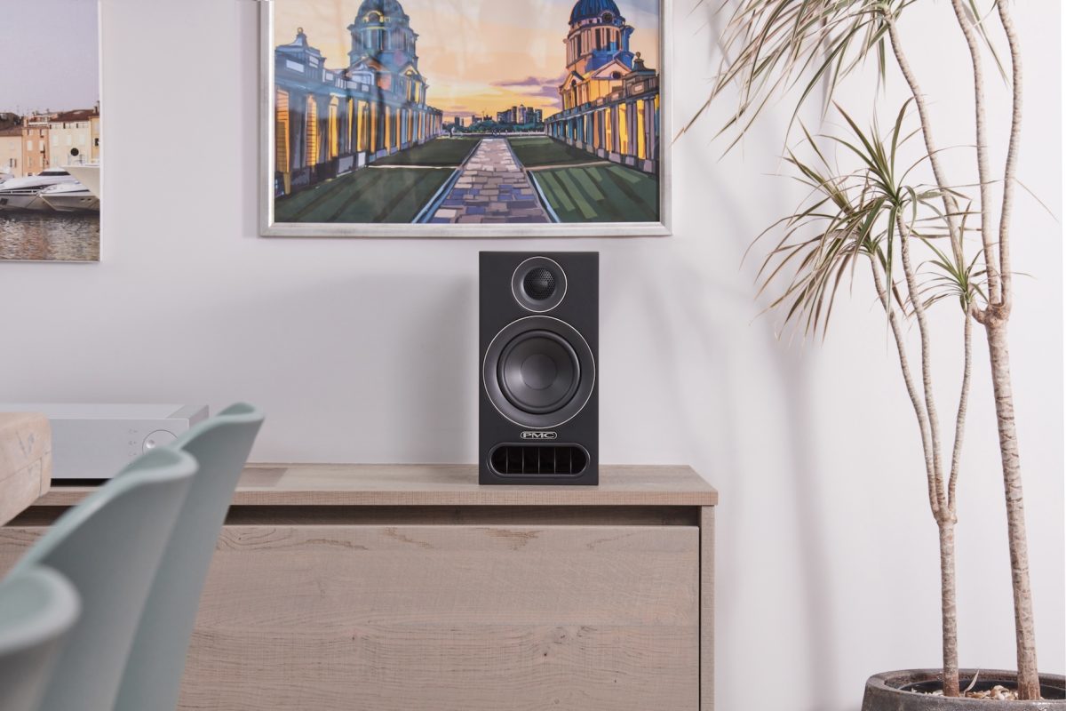 PMC prodigy1 Bookshelf Speakers on sideboard with picture above and plant to the side Lifestyle image