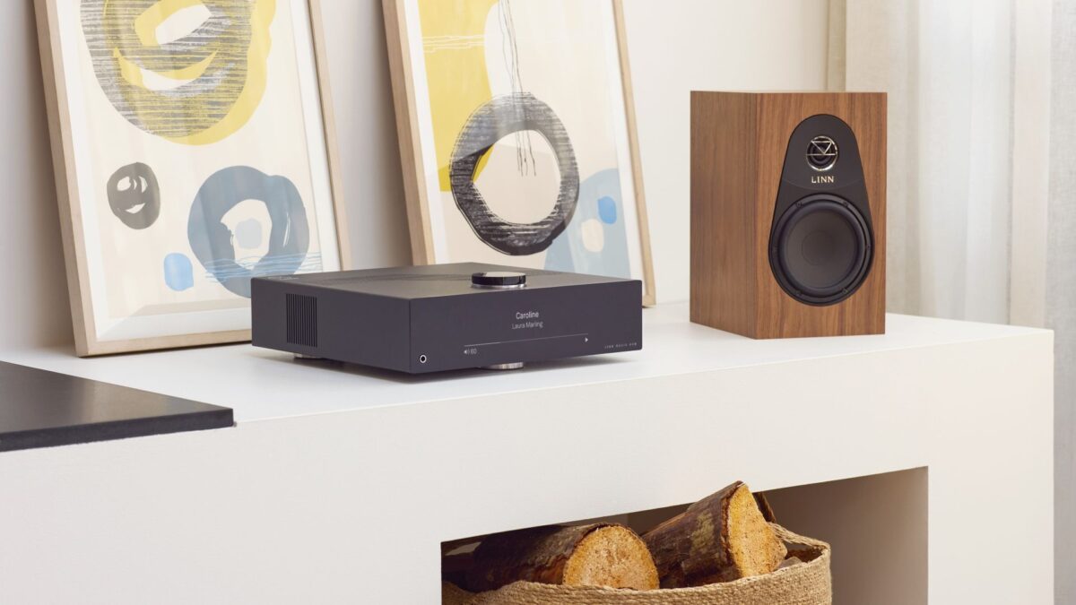 Linn Majik DSM Integrated Amplifier and Streamer New Lifestyle image with 119 stand mount speaker on cabinet with bag of logs underneath and two framed pictures behind, Available at Loud and Clear Hi-Fi, Glasgow, Scotland, UK